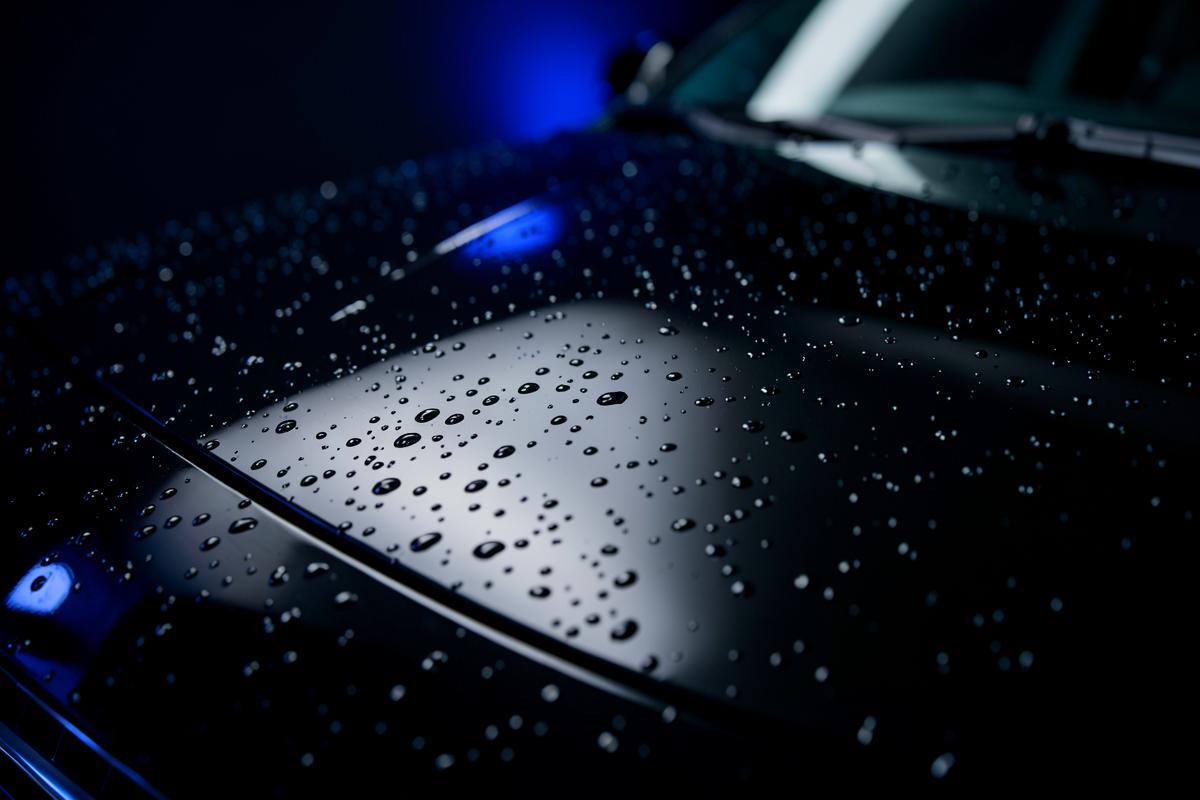 Water beading on a freshly ceramic coated glossy black car hood